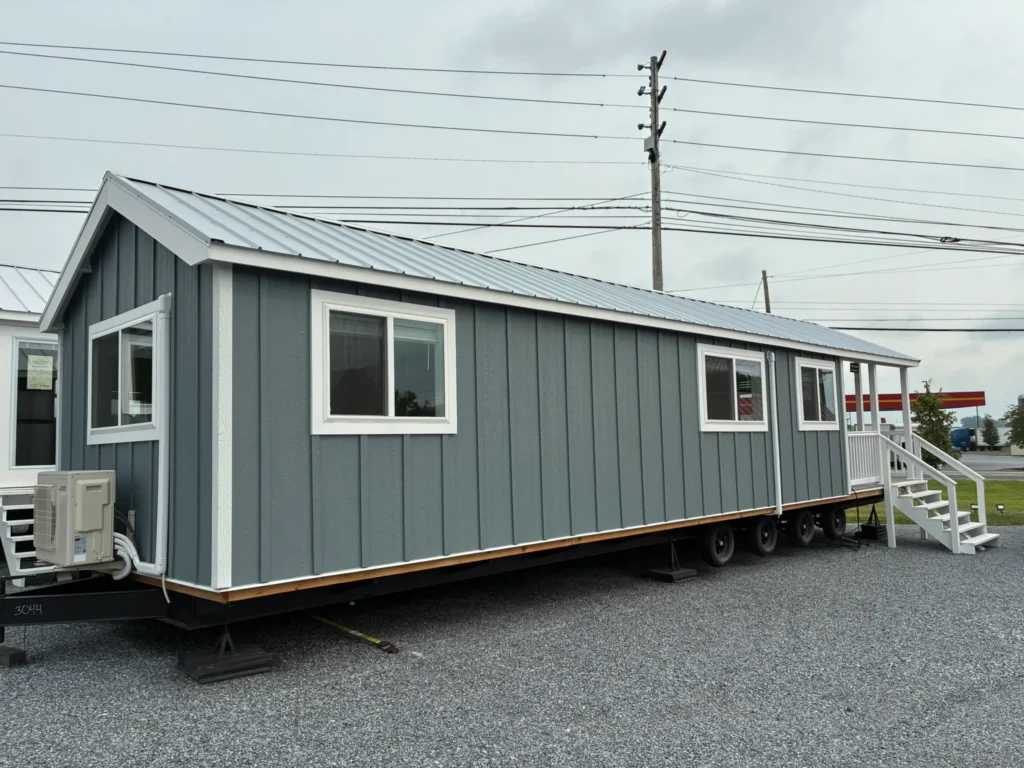 Gray mobile tiny house with white trim and front steps