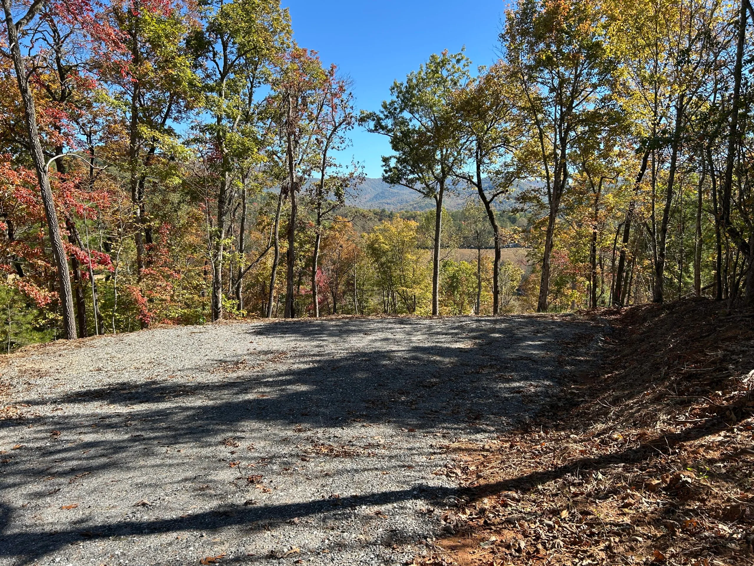 Cleared gravel area surrounded by colorful autumn trees