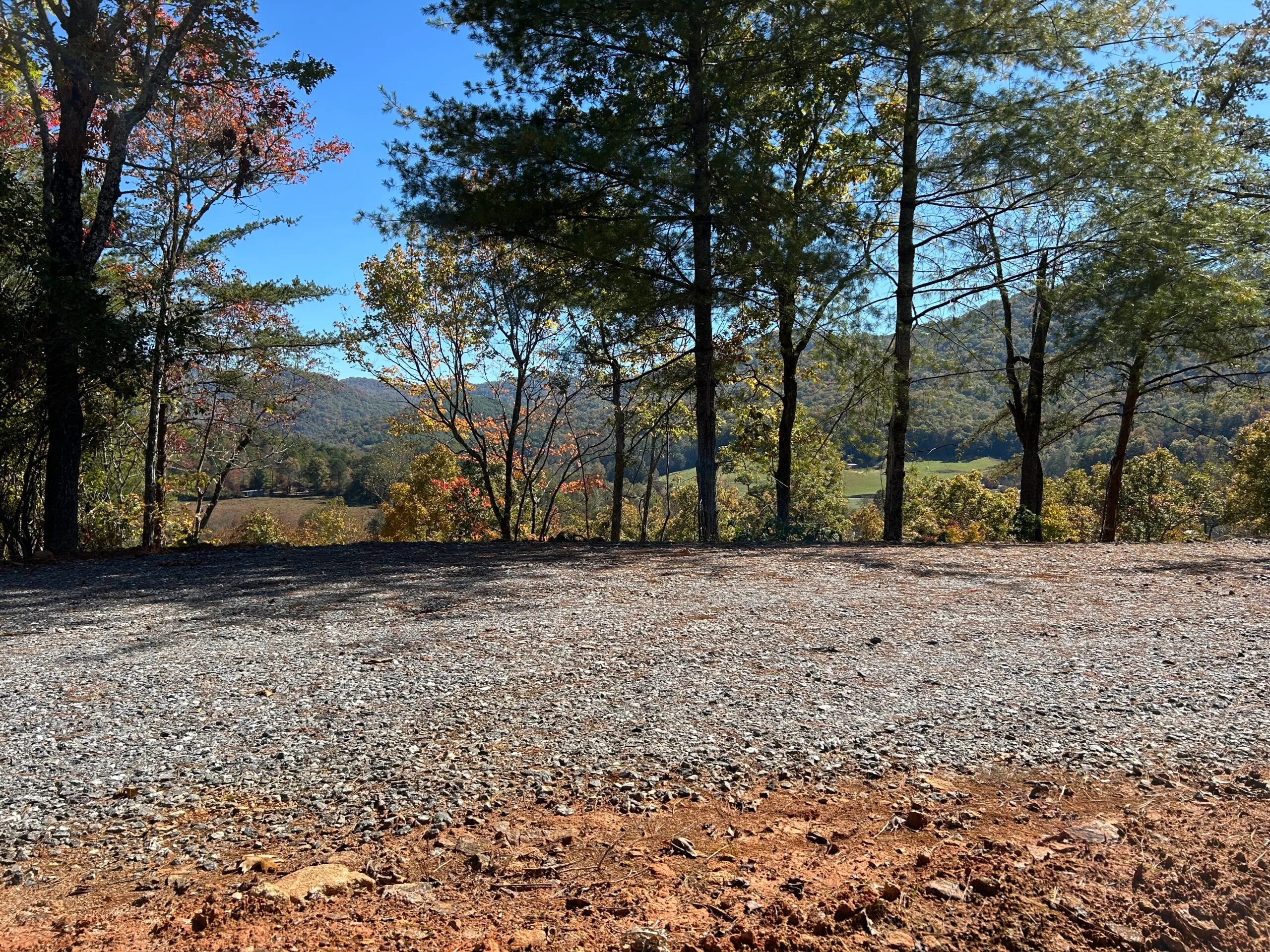 Scenic view of rolling hills and colorful autumn foliage framed by trees