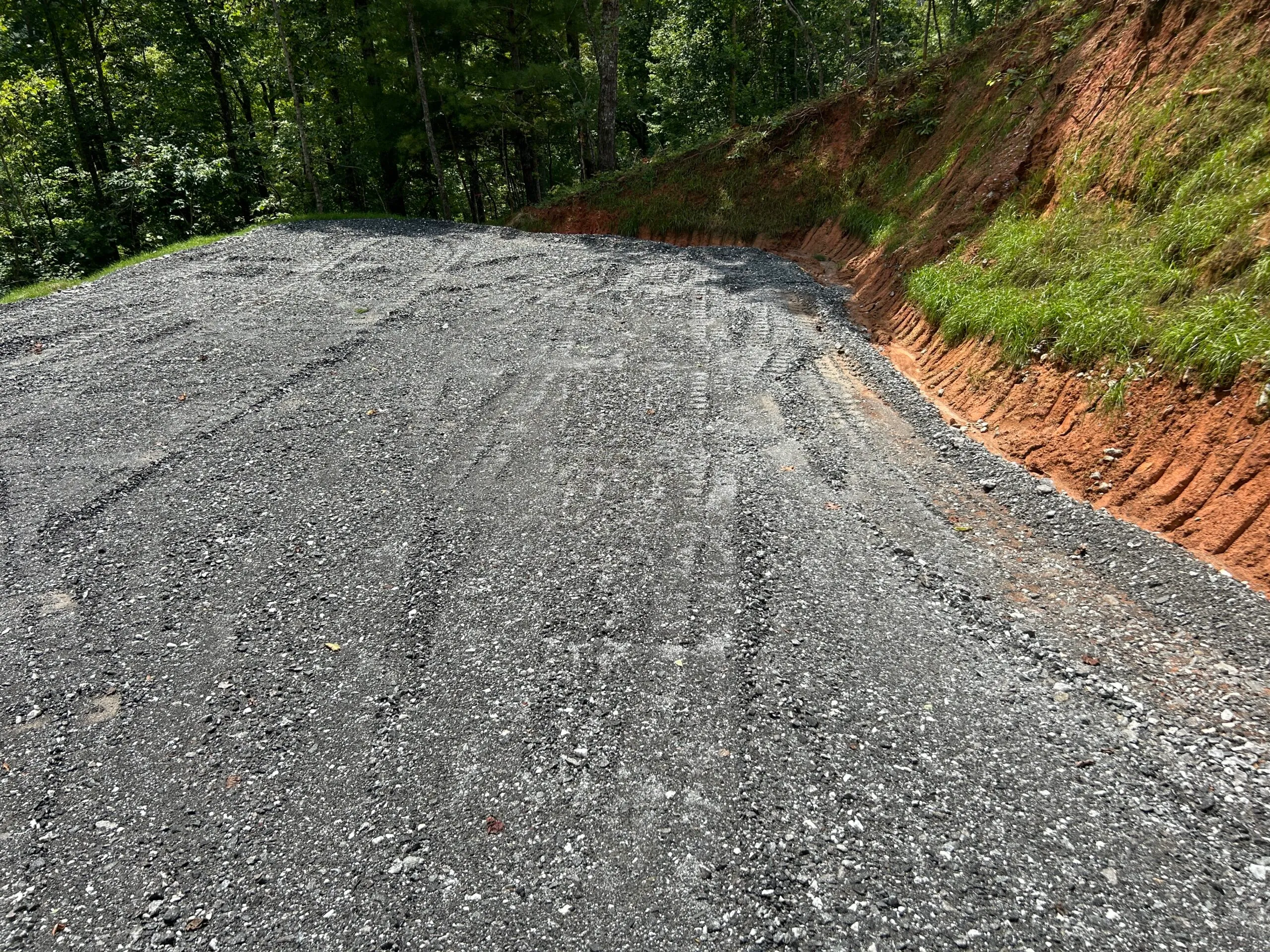Gravel driveway under construction with tire tracks