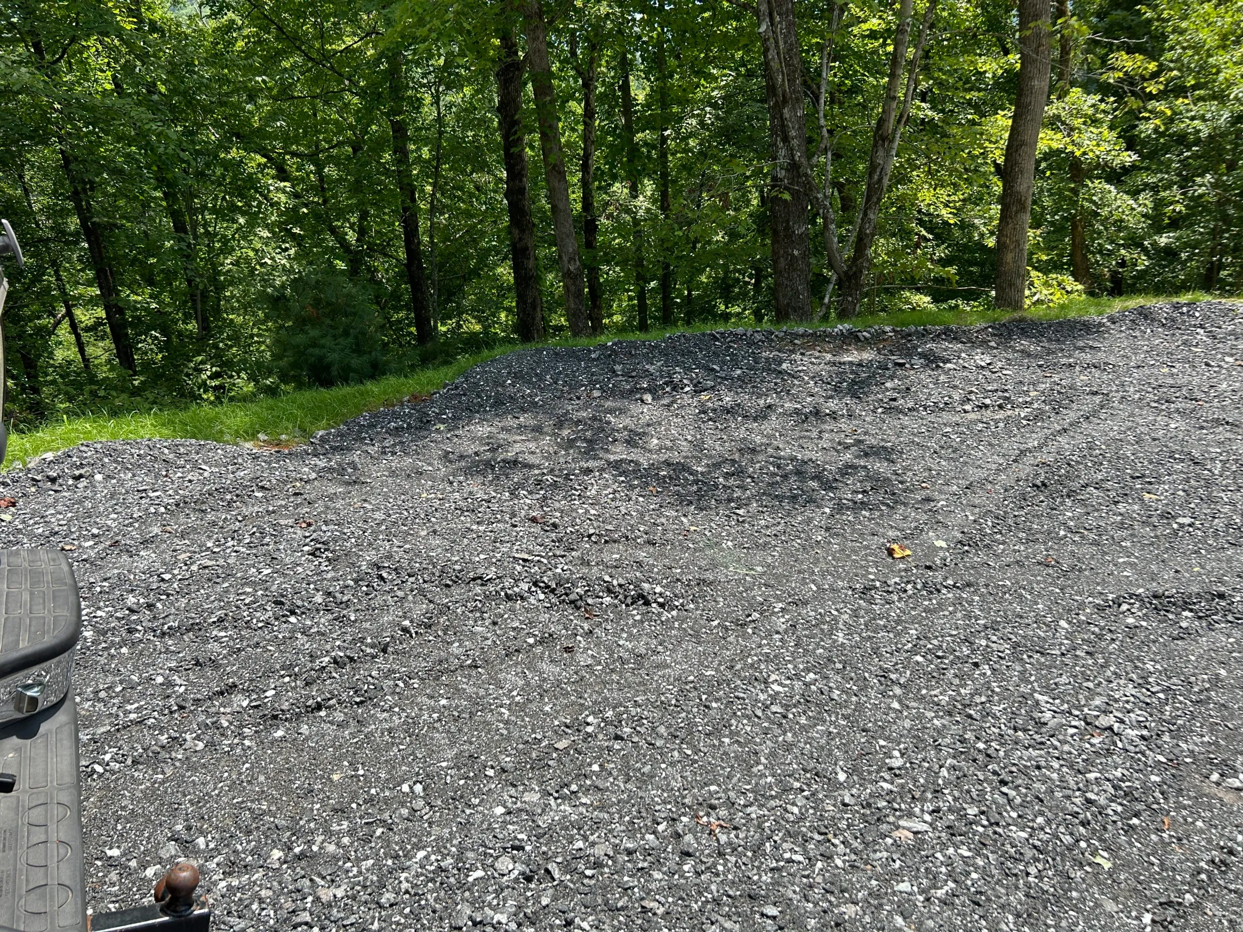 Gravel area cleared among trees, ready for construction or landscaping